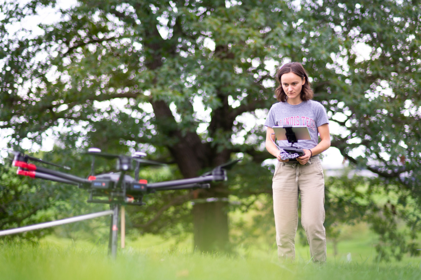 Photograph of an Arboretum student researcher piloting a drone