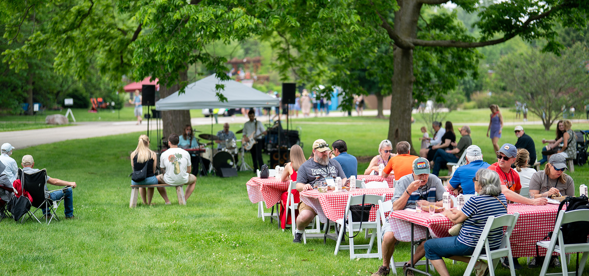 Photograph of visitors at the Blues, Brews, and BBQ event sitting at tables eating BBQ