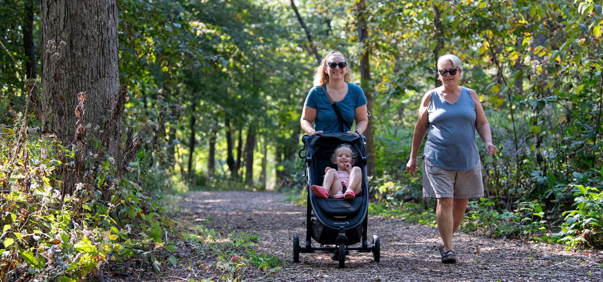 A family walk together down a chipped trail in summer