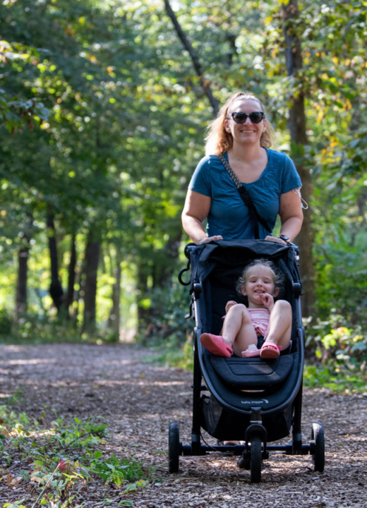 A family walk together down a chipped trail in summer
