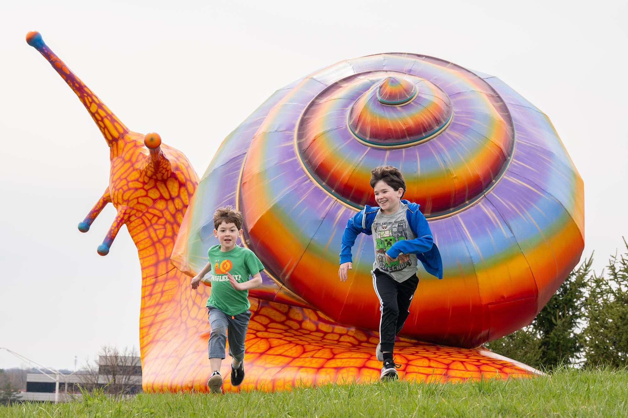 Children run away from the large Vivid Creatures snail, Spectra.