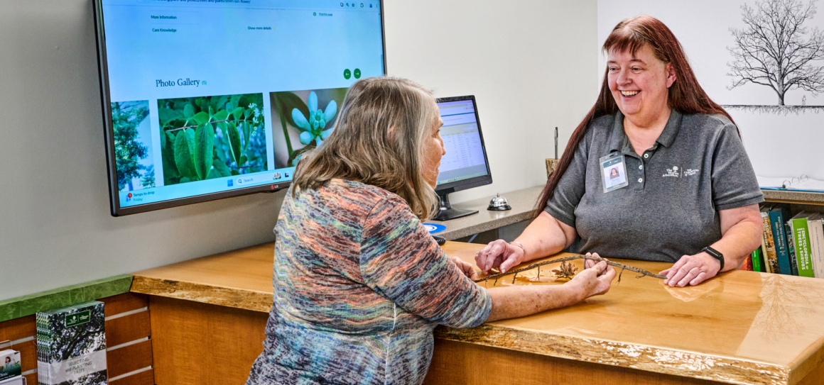 Photograph of Plant Knowledge specialist helping customer at the plant clinic