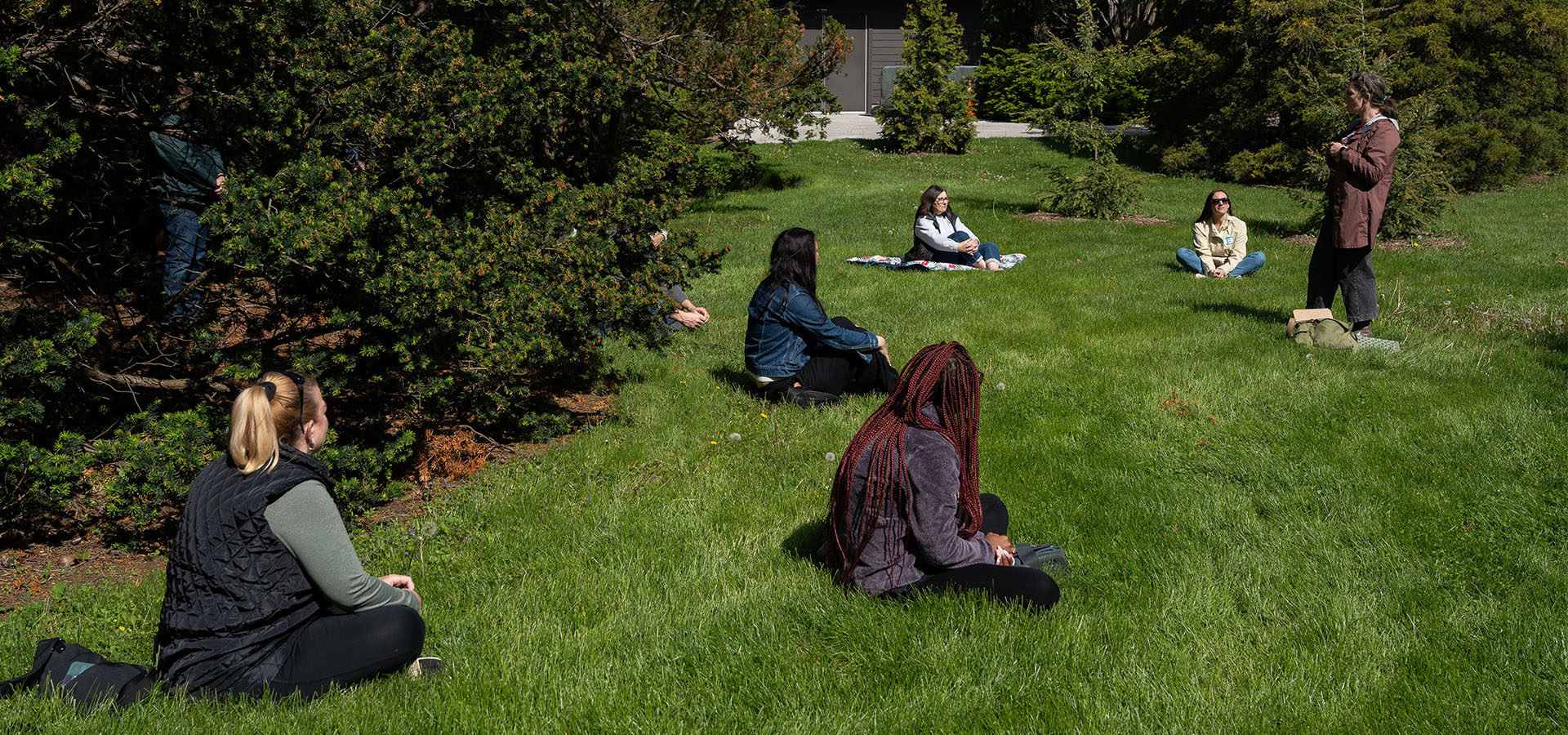 Photograph of people seated on the grass at The Morton Arboretum