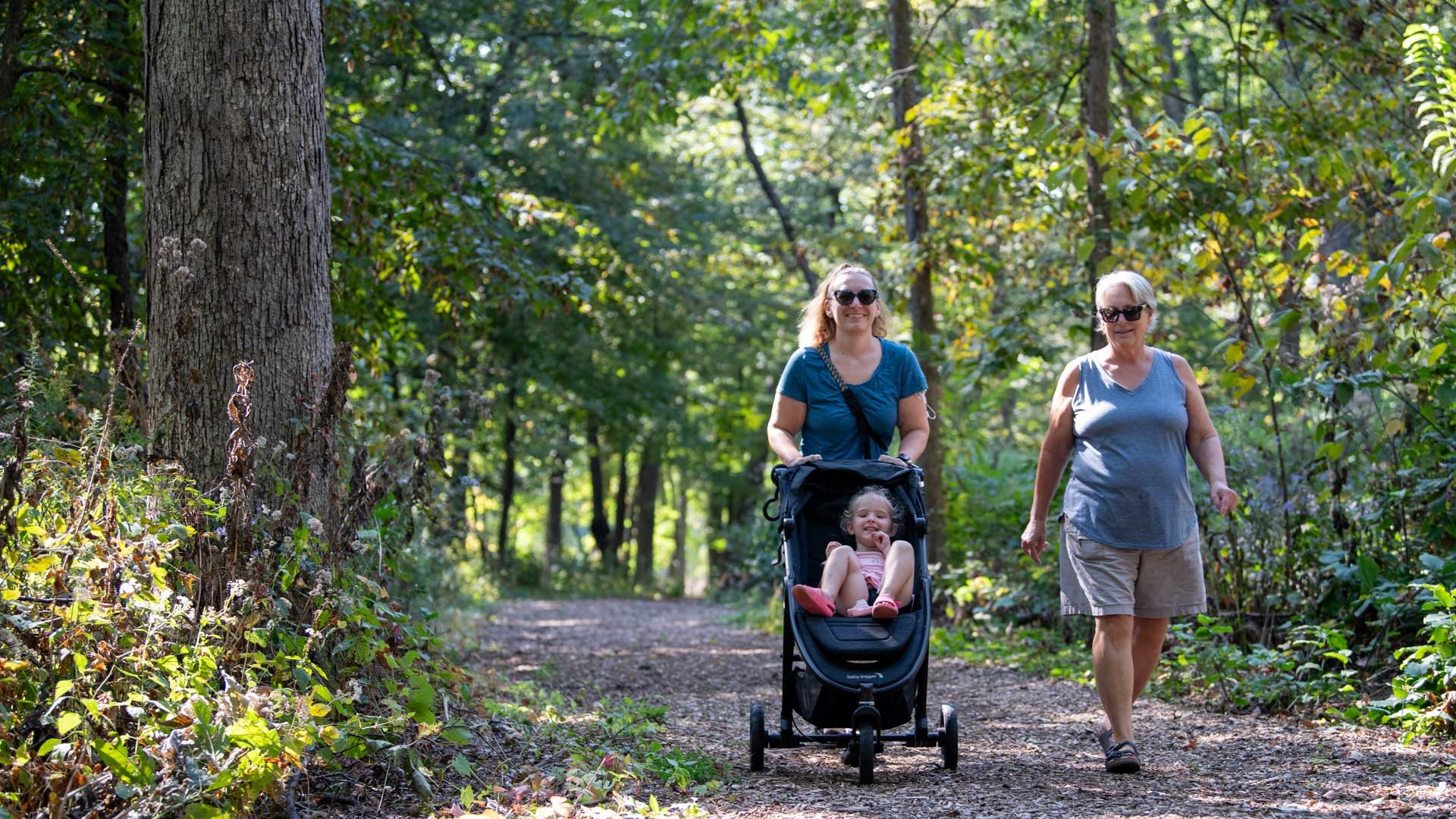 A family hike on a shaded trail among trees