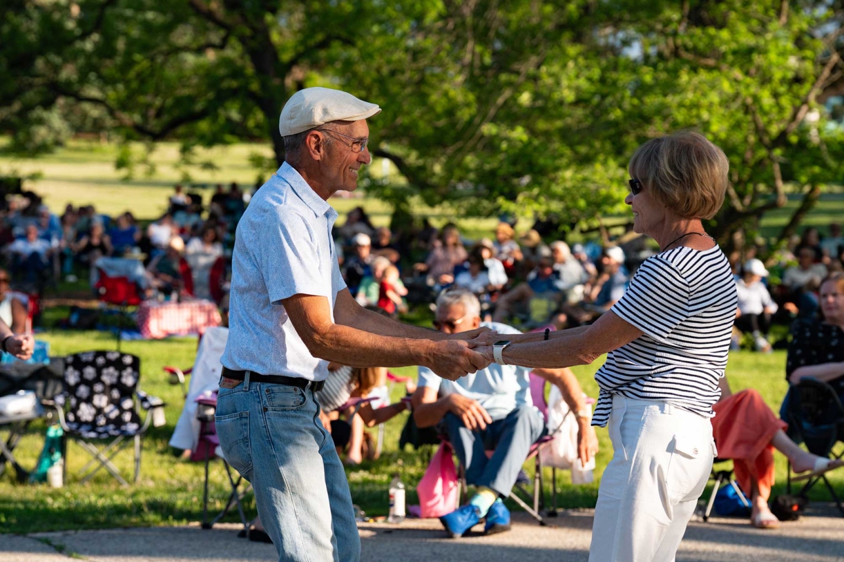 A couple smiles as they dance to music