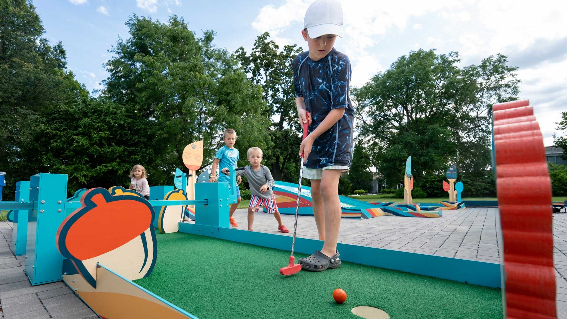Kids play mini golf and cheer each other on