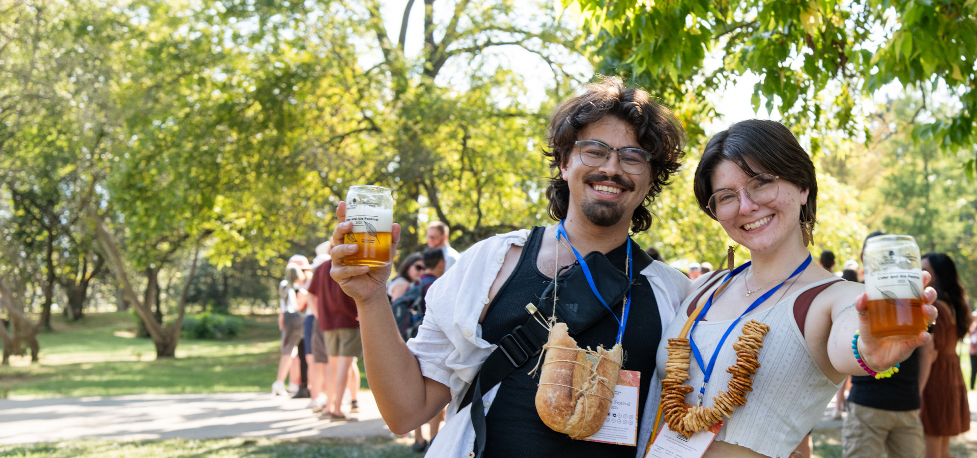 A smiling young couple cheers at the Cider and Ale festival