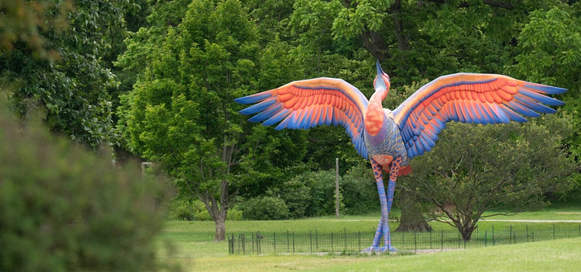 Cadence the Crain sculpture soaks up the sun among the trees