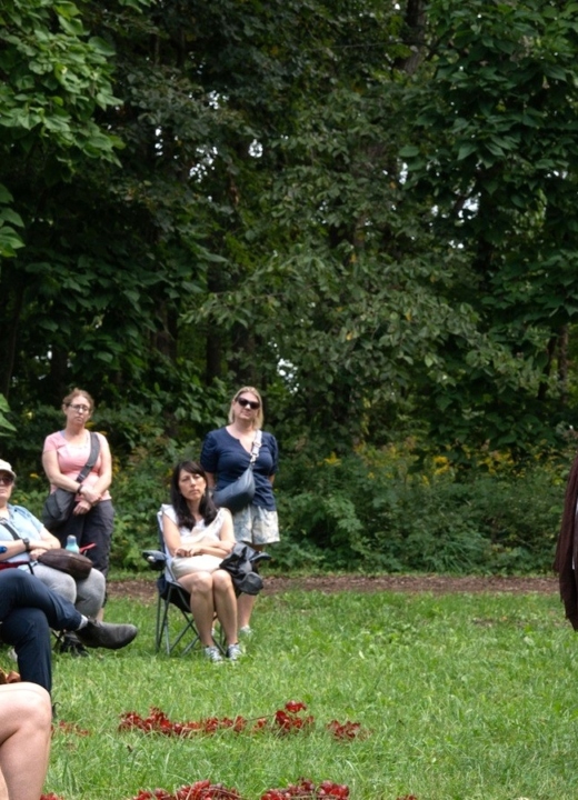 Actors portray a scene in Wuthering Heights for a crowd seated in folding chairs